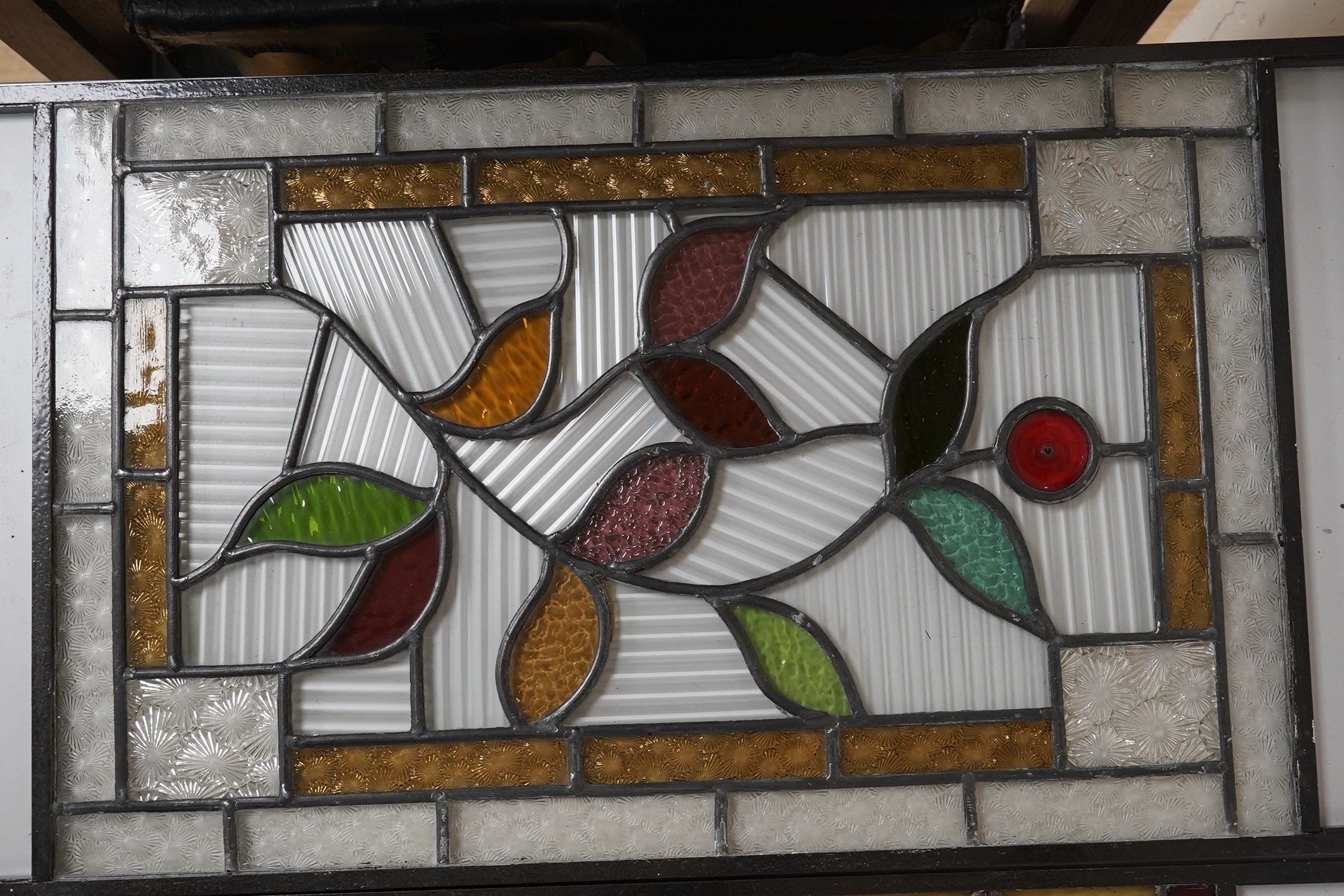 Three stained glass panels in metal frames and a stained glass lantern, longest 55.5cm. Condition - two panels elements of glass broken, lantern good